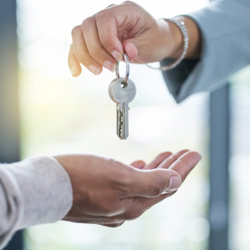 Keys, hands and sale of property, house or real estate investment with realtor and new home. Closeup, hand and key for homeowner buying or renting apartment, building or moving and relocation