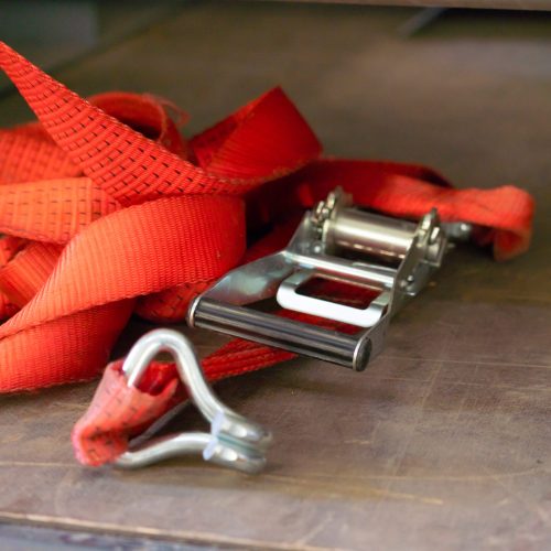 A red lashing strap thrown onto the floor of the truck body